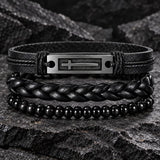 SEYOR men’s black leather and bead bracelet set with a silver-tone cross plate displayed on a rugged dark stone surface.
