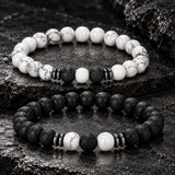 SEYOR men’s two-piece beaded bracelet set with matte black lava stones, white howlite beads and dark metallic spacers on a rugged stone surface.