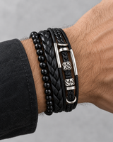 Man wearing a SEYOR black multi-layer bracelet set with polished beads, braided leather bands and silver-tone accents.