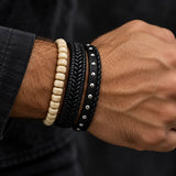 Man wearing a SEYOR three-piece bracelet set with ivory beads, black braided leather and polished silver-tone stud details.