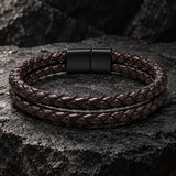 SEYOR men’s coffee-brown double-braided leather bracelet with a matte black magnetic clasp on a rugged stone surface.