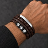 Man wearing a SEYOR multilayer coffee brown leather bracelet featuring braided straps, a polished silver-tone bar and silver spacer details.