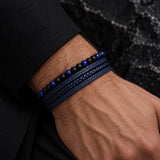 Close-up of a SEYOR men’s navy blue multilayer leather bracelet featuring braided bands, matte black beads and polished blue stone accents.
