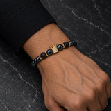 Man wearing a SEYOR black hematite and lava stone bracelet with a gold crystal crown centerpiece