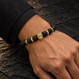 Man wearing a SEYOR black lava stone bracelet with a gold leopard head centerpiece and crystal spacers