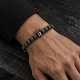 Man wearing a SEYOR gunmetal beaded bracelet with textured details and a polished crown centerpiece