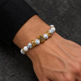 Man wearing a SEYOR white howlite bead bracelet featuring three gold crowns and blue crystal accents