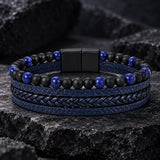 Man wearing a SEYOR navy blue multilayer leather bracelet with braided detailing, matte black beads and blue stone accents.