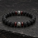 Close-up of SEYOR men's black lava bead bracelet with grey stone centerpiece and dark red wooden spacers