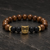 Close-up of SEYOR men's brown wooden and matte black beaded bracelet with a gold owl centerpiece