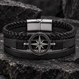 Close-up of a SEYOR men’s black multilayer leather bracelet featuring braided detailing, a silver-tone compass centerpiece and magnetic clasp.