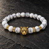 Close-up of SEYOR men's white howlite bracelet featuring an antique gold leopard charm and crystal detailed spacers