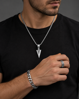 Man wearing a SEYOR silver-tone arrowhead necklace, Cuban chain bracelet and engraved chain-detail ring with a black shirt.