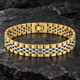 Men’s two-tone stainless steel bracelet with polished gold outer links, silver center links, and a secure fold-over clasp on a dark stone surface.