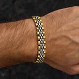 Close-up of a man wearing a polished gold and silver-tone stainless steel link bracelet.