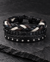 Black, brown and cream men’s bracelet set arranged on a dark stone surface