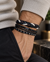 Men wearing a layered four-piece bracelet set with braided bands, square beads and silver-tone studs