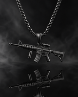 Detailed black tactical M4 rifle pendant and box chain displayed across rugged volcanic rocks