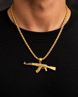 Man wearing a SEYOR gold-tone AK rifle pendant necklace over a black shirt