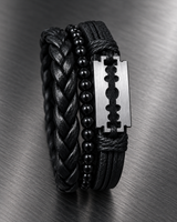 Detailed view of an all-black men’s bracelet set with braided texture, round beads and blade centerpiece