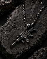 SEYOR black M4 rifle pendant necklace arranged on a textured dark stone surface with dramatic smoke